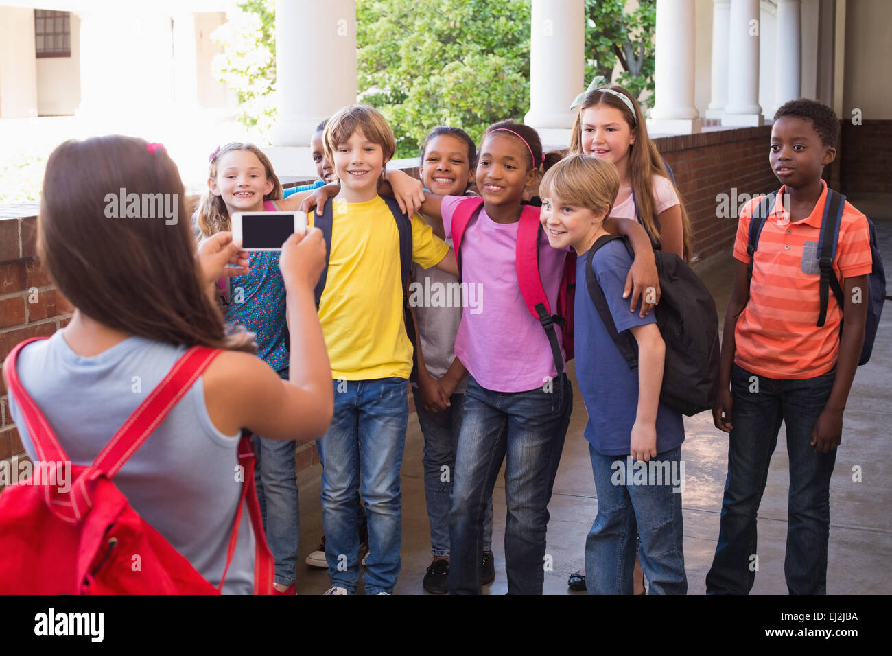 Niedlichen Schülerinnen und Schüler mit Handy Stockfoto
