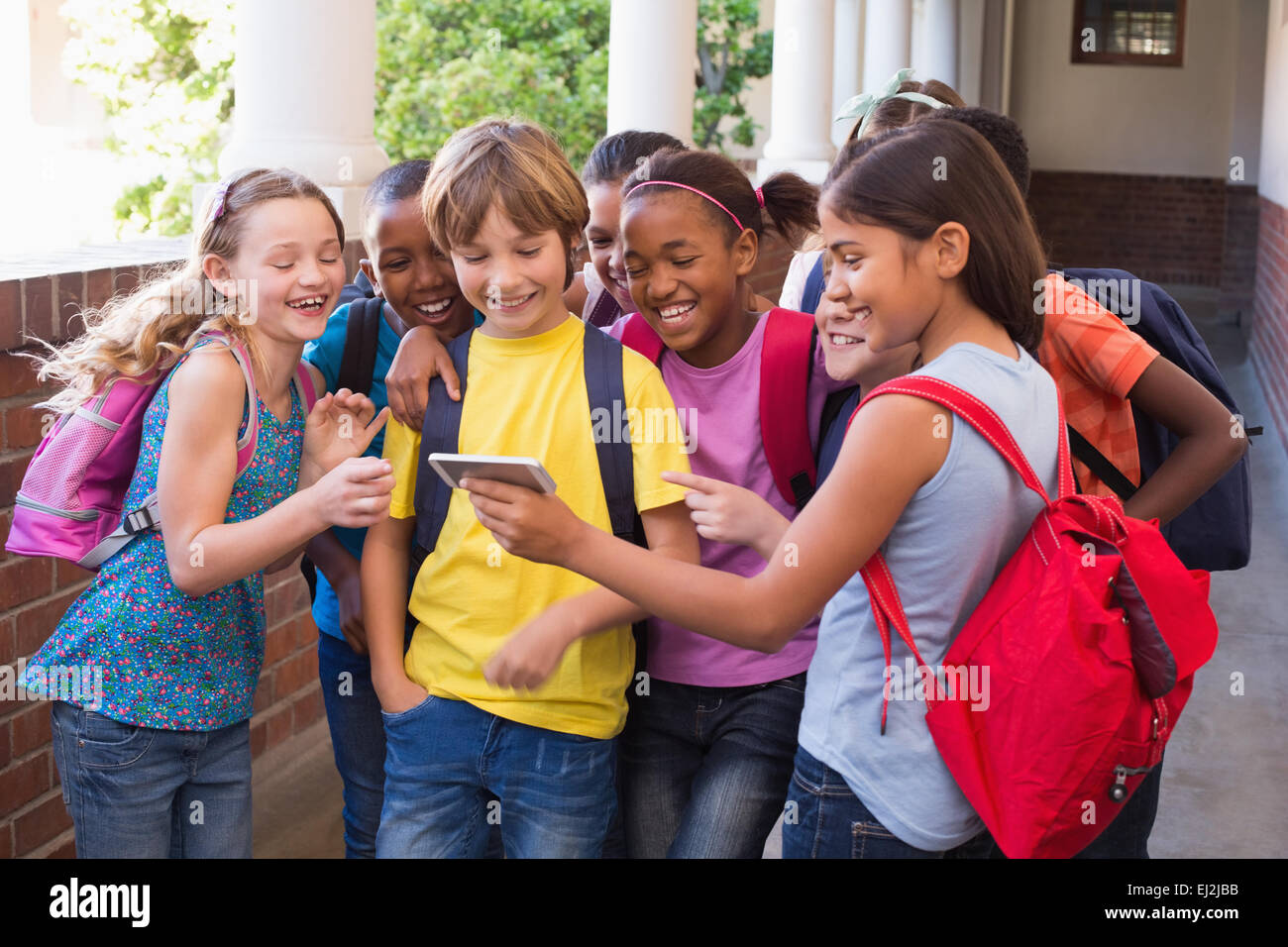 Niedlichen Schülerinnen und Schüler mit Handy Stockfoto