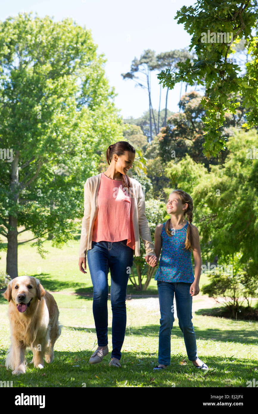 Mutter und Tochter im Park mit Hund spazieren Stockfoto