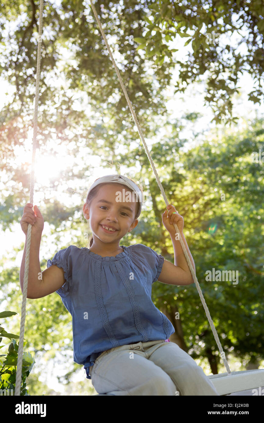 Glückliches kleines Mädchen auf einer Schaukel im park Stockfoto
