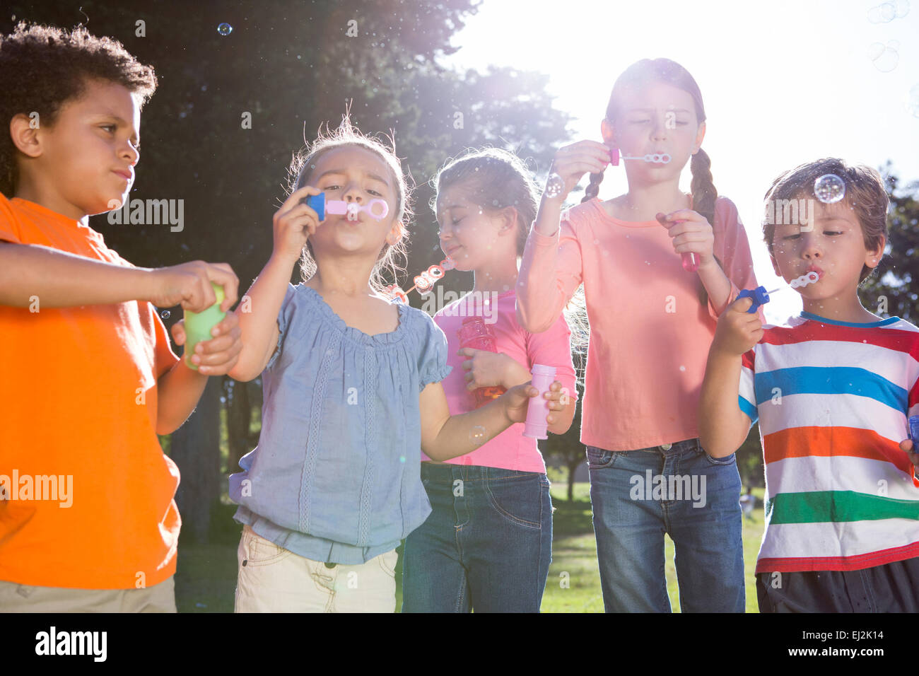 Kleinen Freunde Seifenblasen im park Stockfoto