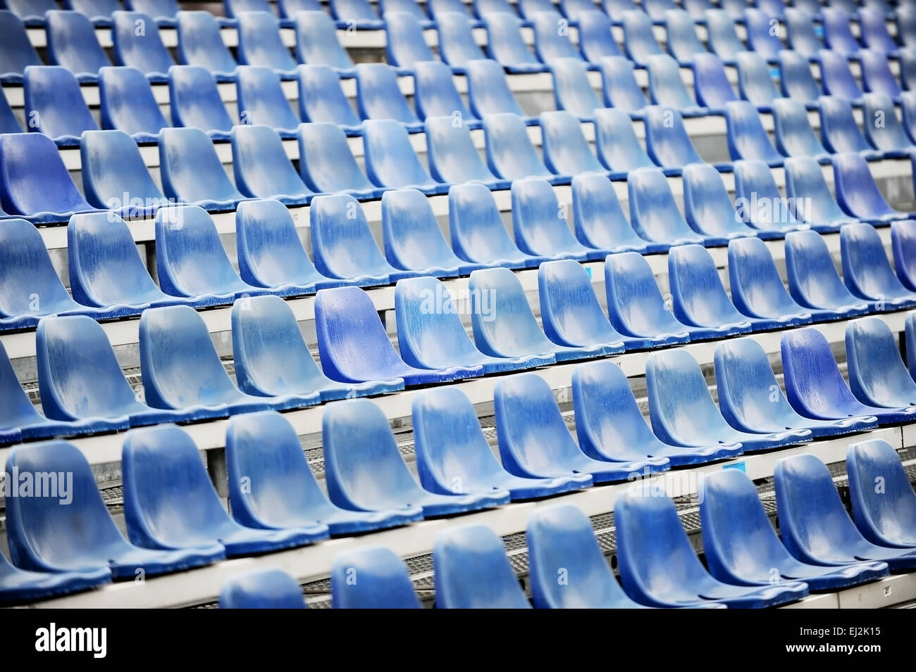 Leere blaue Sitze auf Sport-Arena-Tribüne nach dem Regen Stockfoto