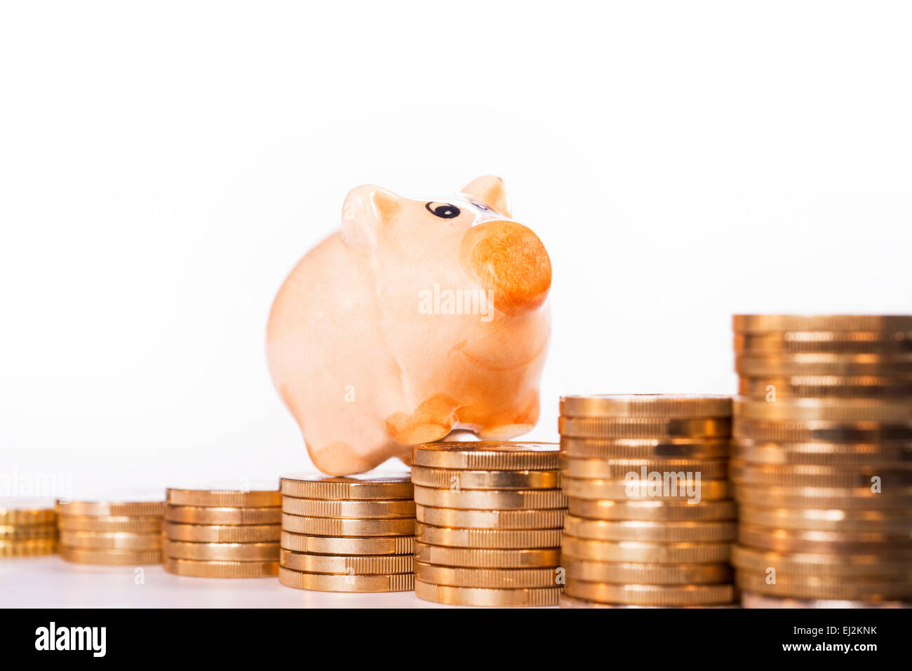 Piggy Bank stehend auf Haufen von Münzen. Stockfoto