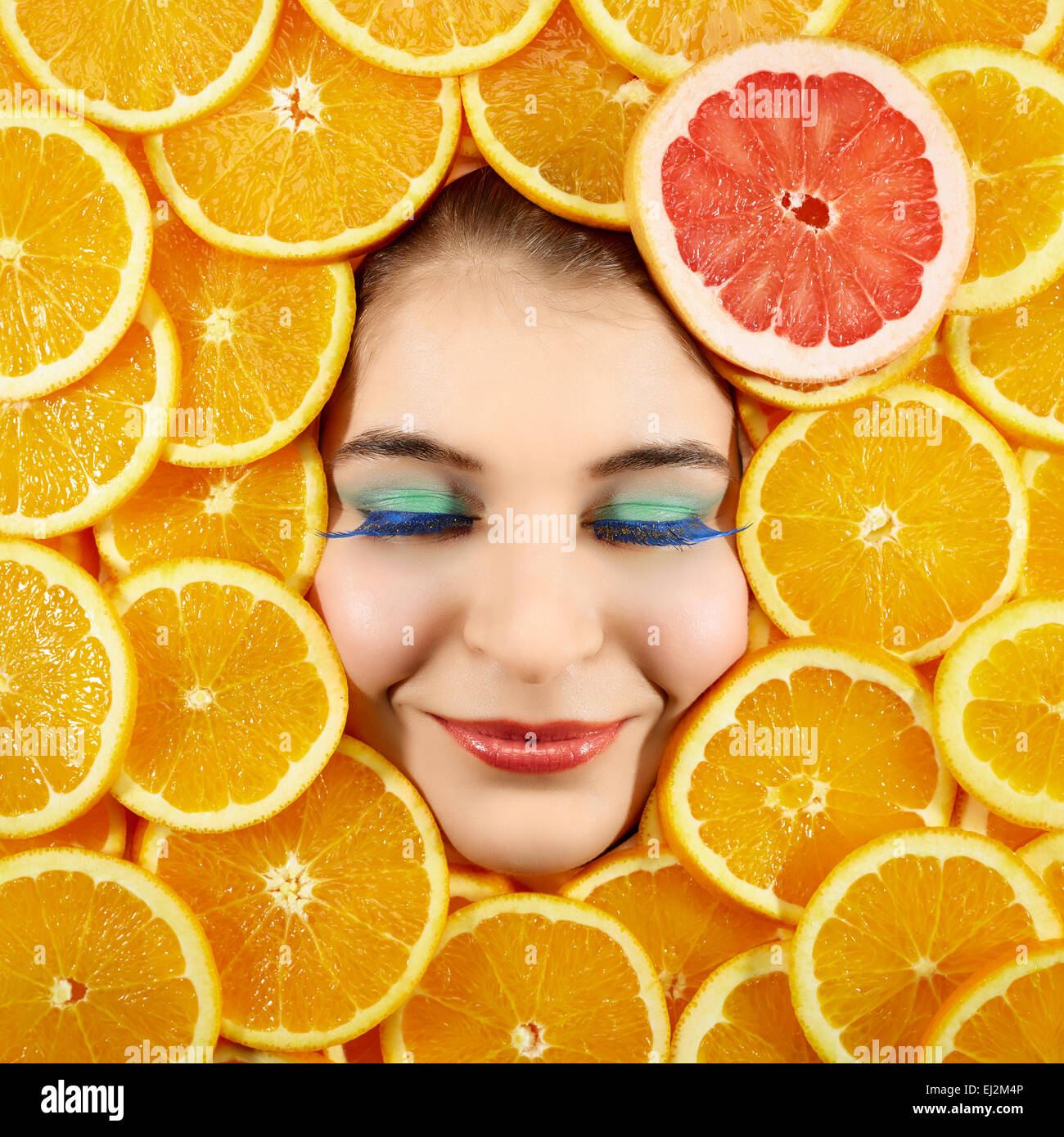 Schöne Frau Ausdruck Gesicht mit Orangenscheibe Rahmen Stockfoto