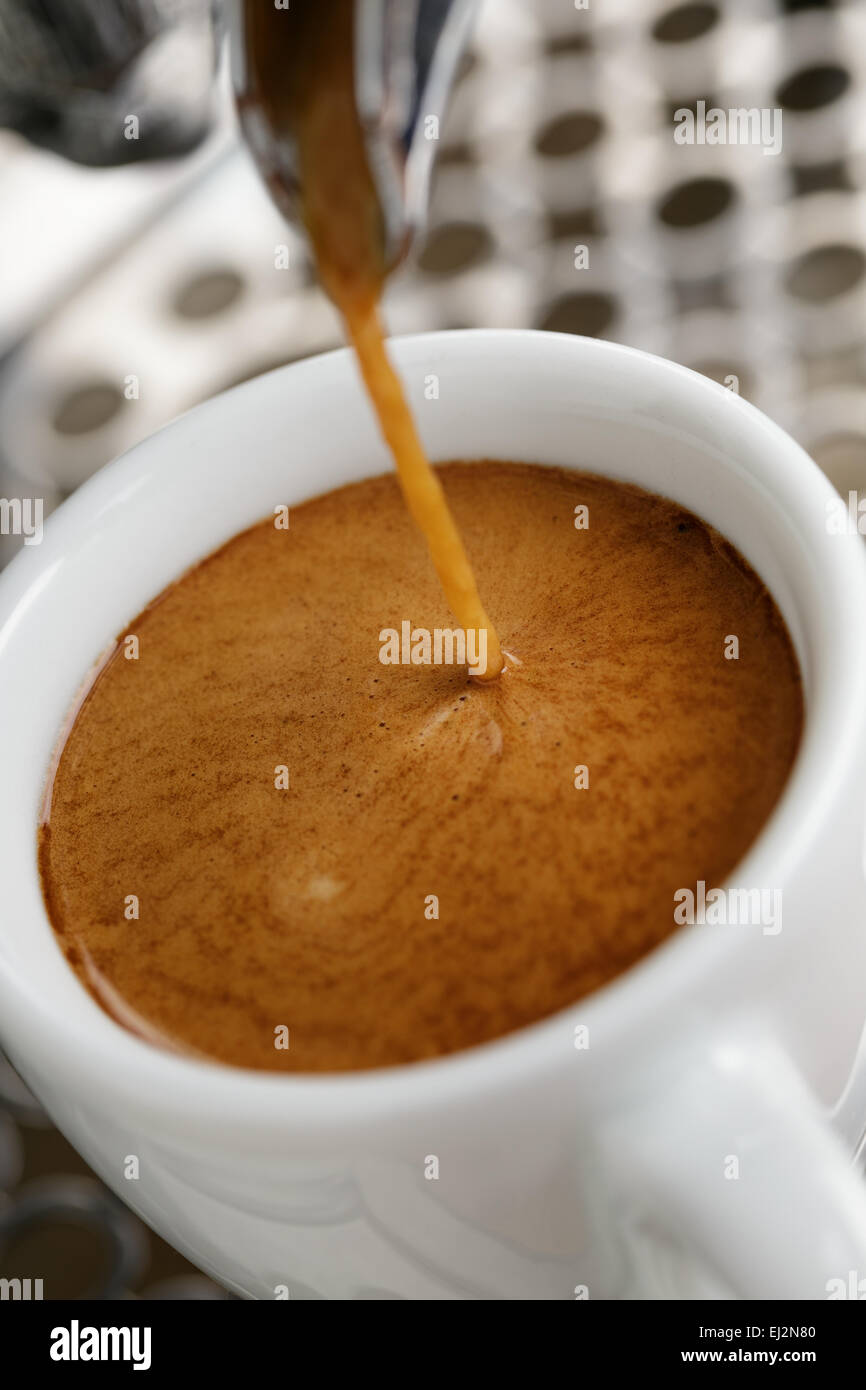 Gießen von professionellen Kaffeemaschine in weißen Tasse Espresso Stockfoto