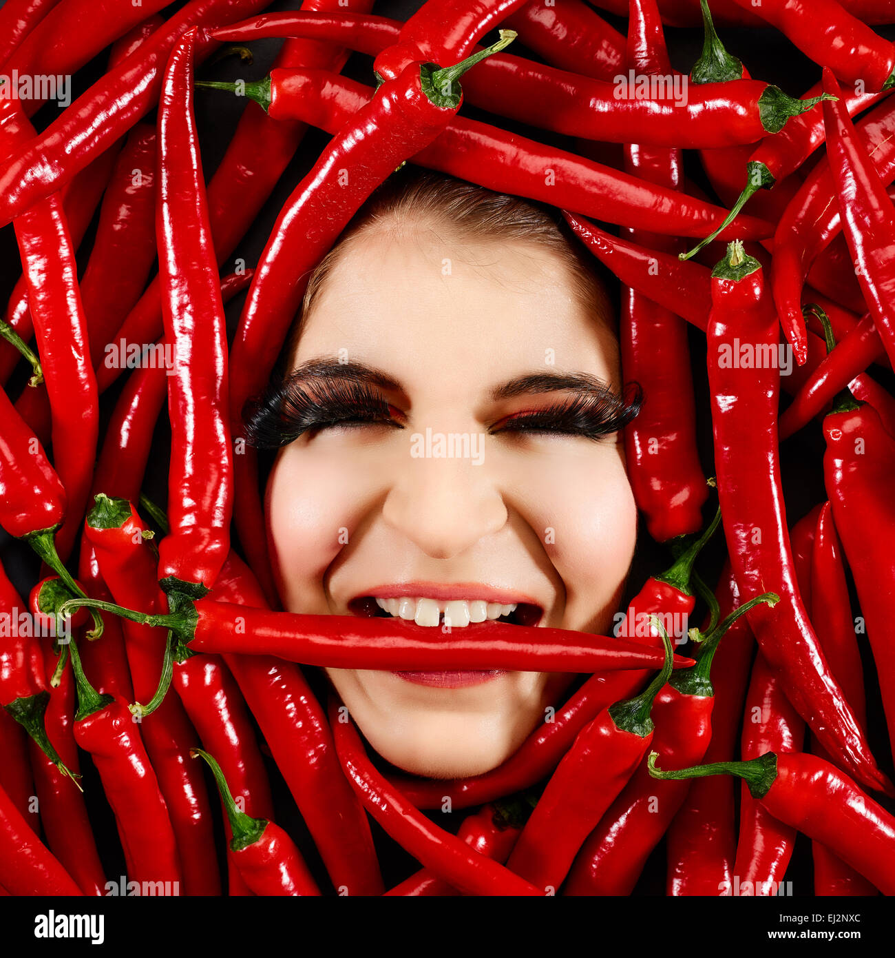 Schöne Frau Ausdruck Gesicht mit roten Chili-Pfeffer-Rahmen Stockfoto