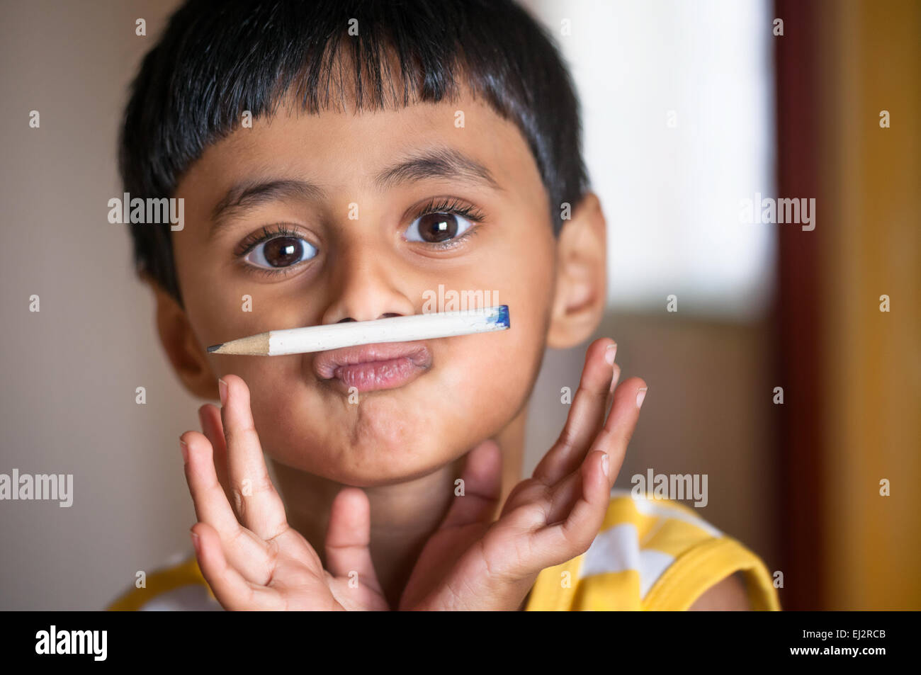 Porträt eines Nauhty Kind mit weißen Stift als seinen Schnurrbart. Stockfoto