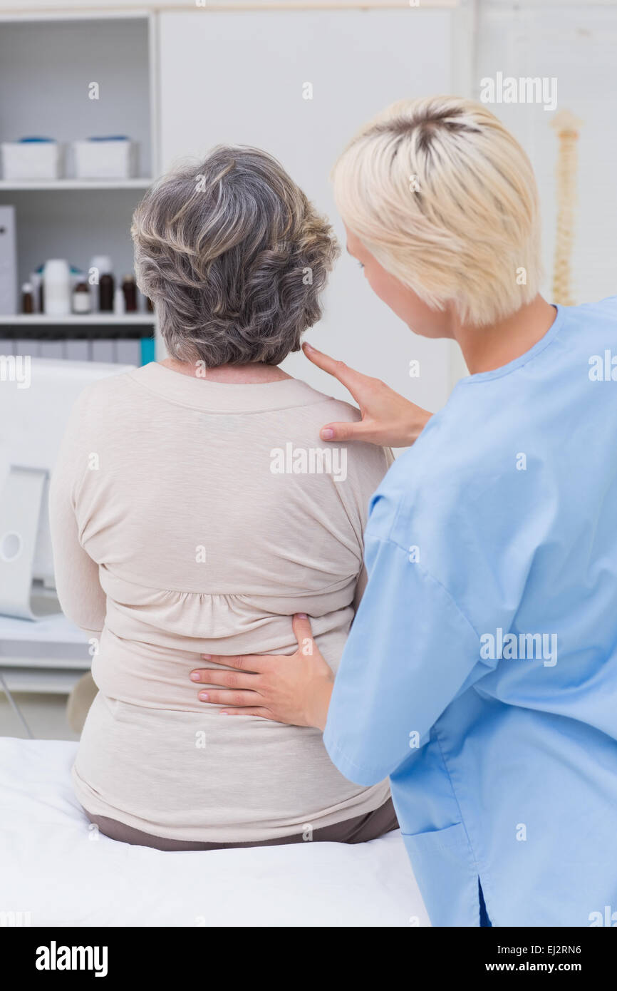 Krankenschwester untersuchen Patienten wieder in Klinik Stockfoto