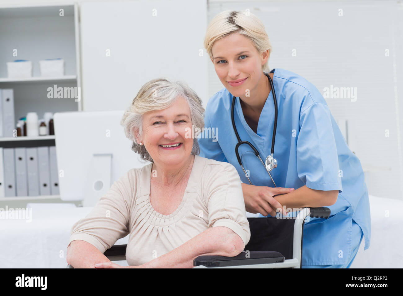 Krankenschwester, stützte sich auf ältere Patienten Rollstuhl in Klinik Stockfoto