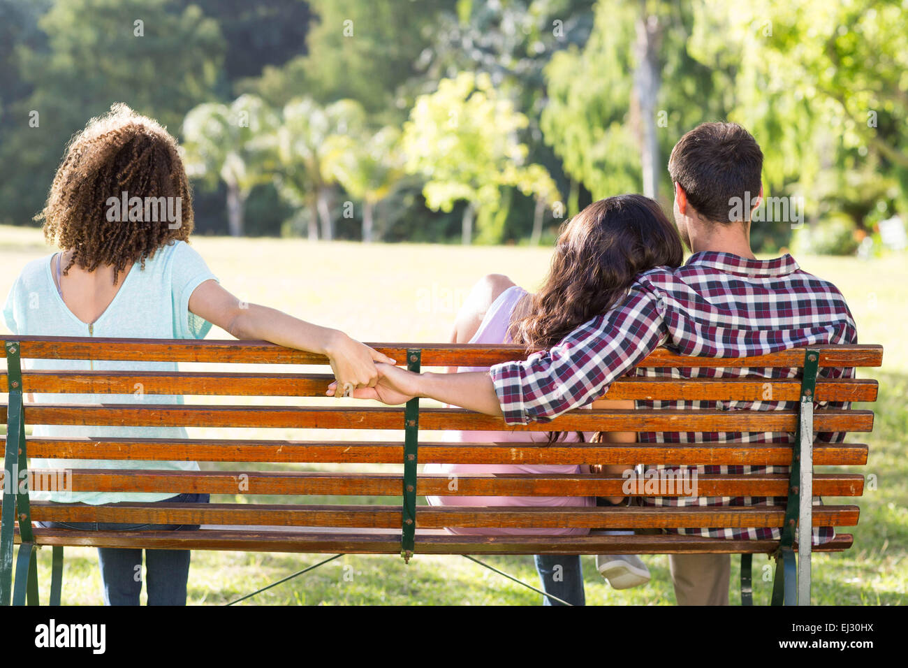 Einsame Frau sitzend mit paar im park Stockfoto