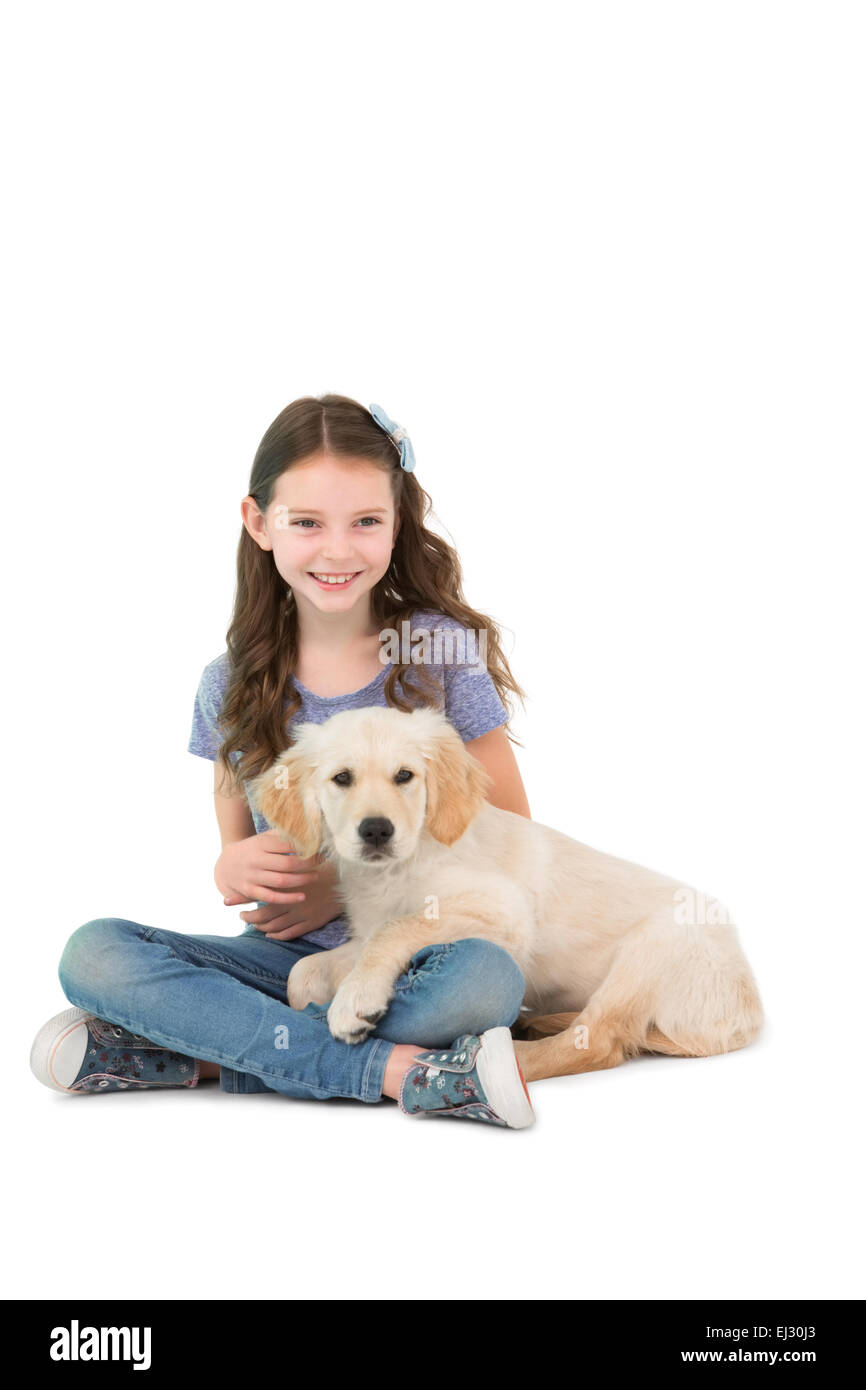Glückliches kleines Mädchen mit Hund an den Beinen sitzen Stockfoto
