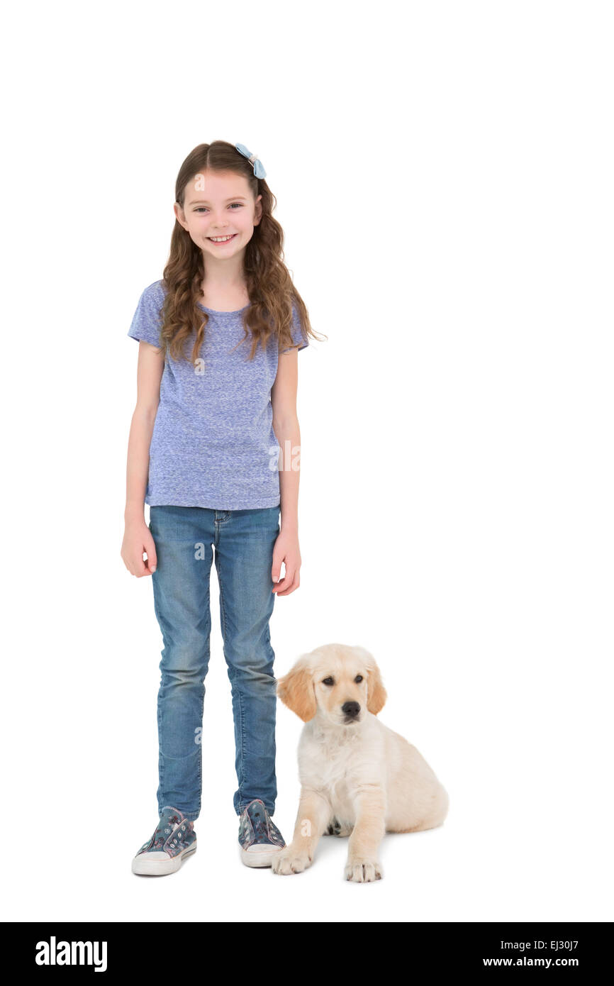 Lächelnde Mädchen stehen neben Hund Stockfoto