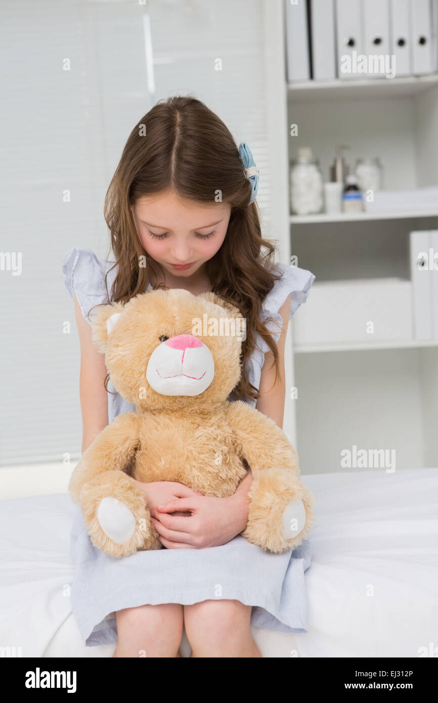 Kleines Mädchen mit ihren Teddybär in ihr schadet Stockfoto