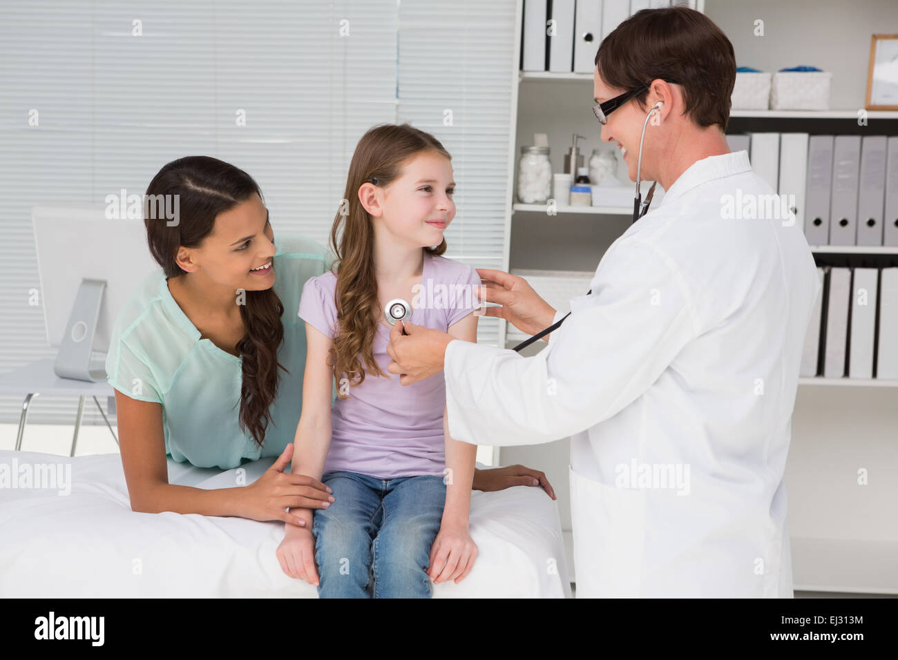 Arzt untersucht kleines Mädchen mit ihrer Mutter Stockfoto
