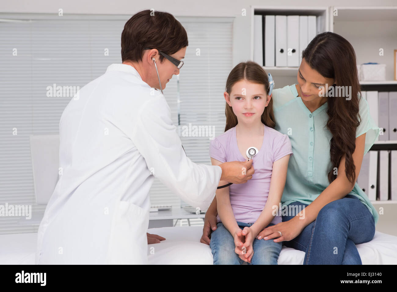 Arzt untersucht kleines Mädchen mit ihrer Mutter Stockfoto