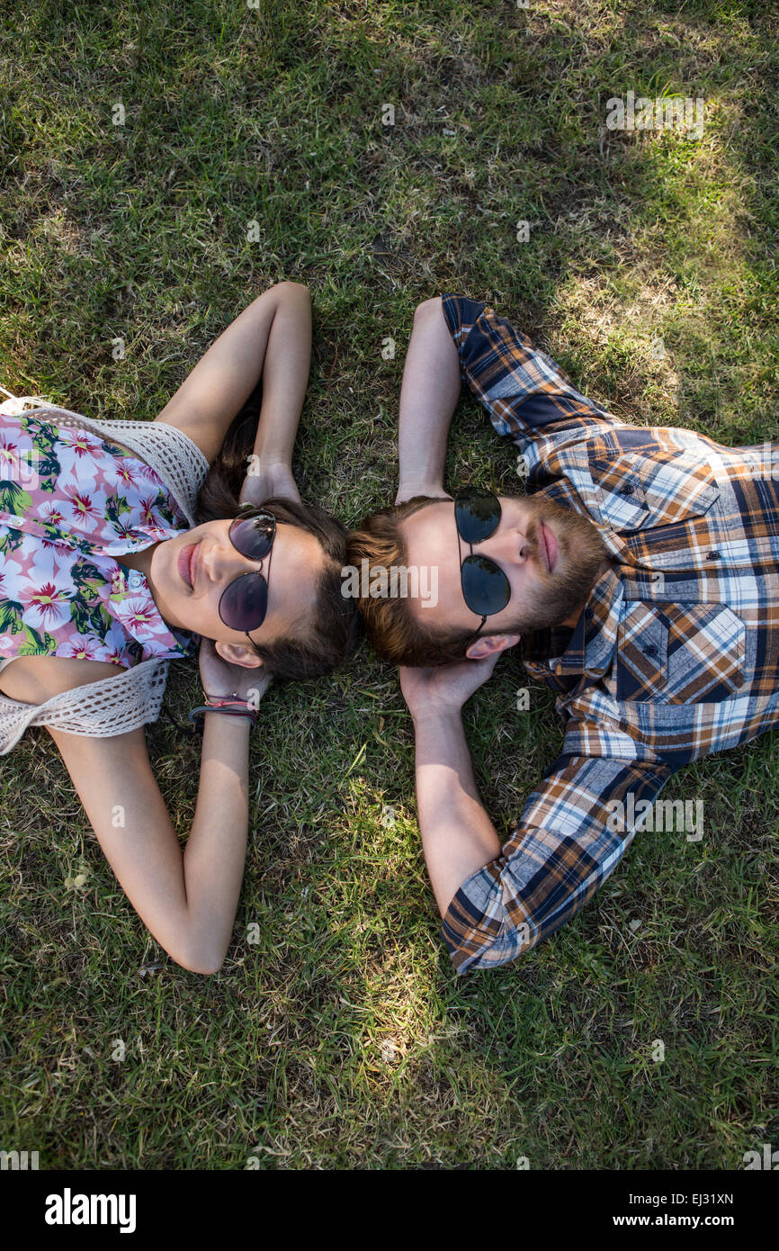 Junges Paar liegen auf dem Rasen in die Kamera Lächeln Stockfoto