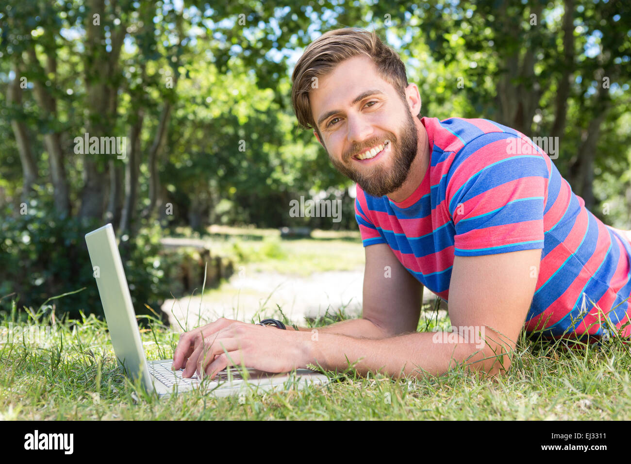 Hipster mit Laptop im park Stockfoto