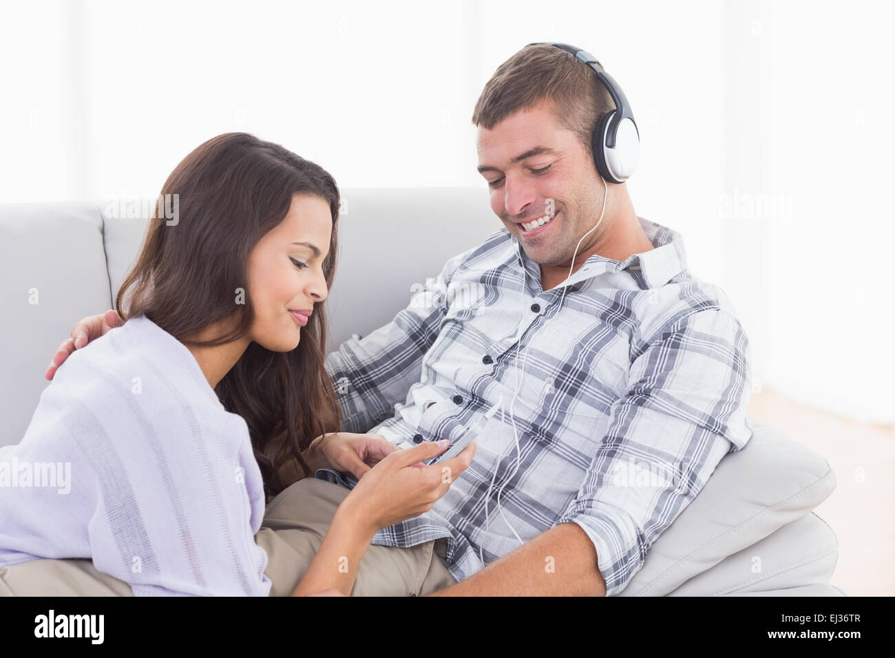 Frau spielt Musik für Mann auf dem Handy Stockfoto
