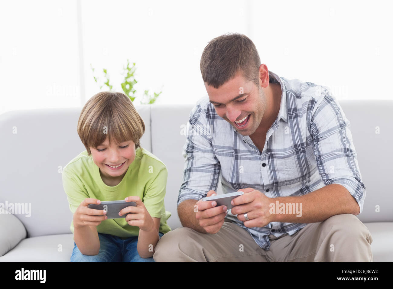 Vater und Sohn spielen auf dem Handy Stockfoto