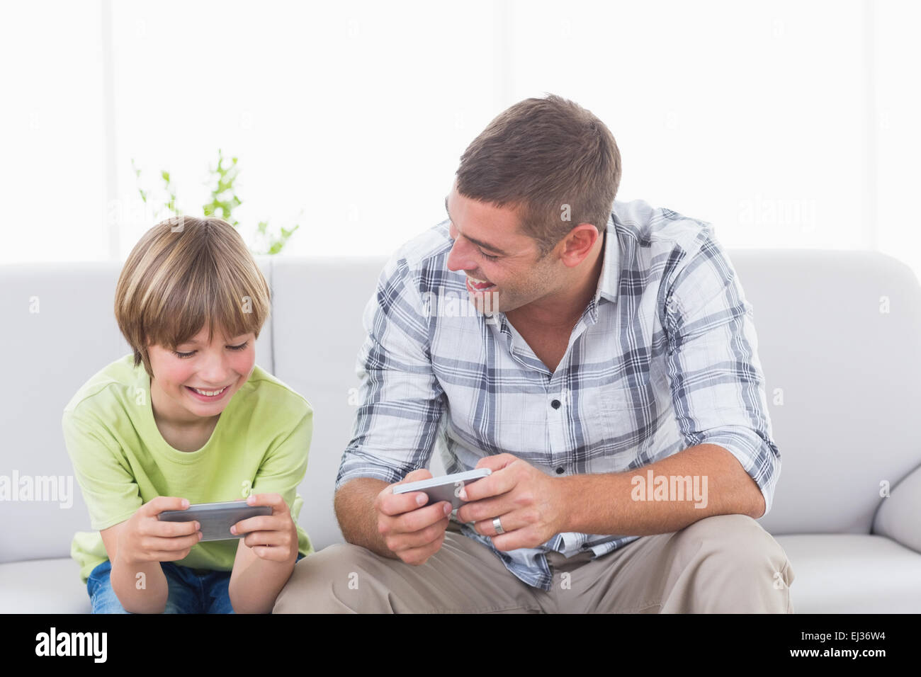 Vater und Sohn spielen auf Handy Stockfoto