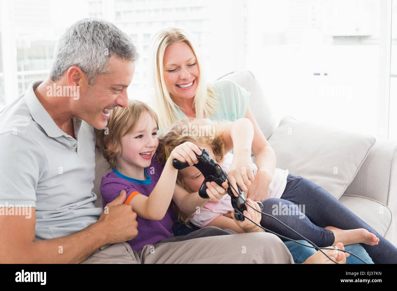Eltern, die Kinder spielen Videospiel zu betrachten Stockfoto
