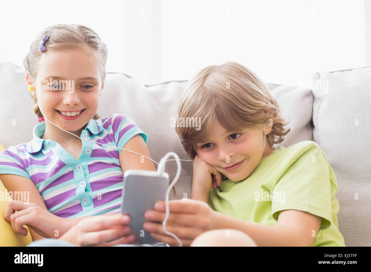 Geschwister, hören Musik über Handy zu Hause Stockfoto