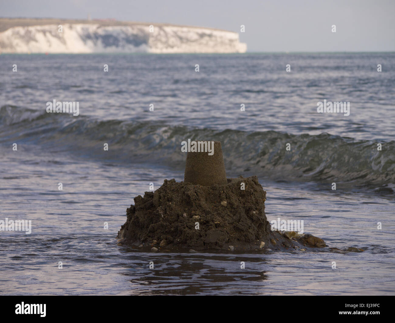 Eine Sandburg, von einer Welle getroffen und weggespült Stockfoto