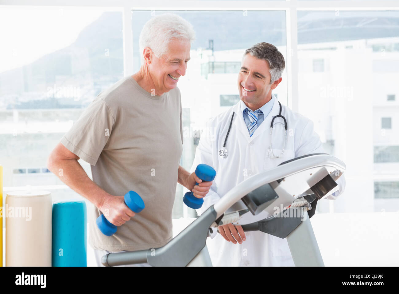 Senior woman auf Laufband mit Therapeuten Stockfoto