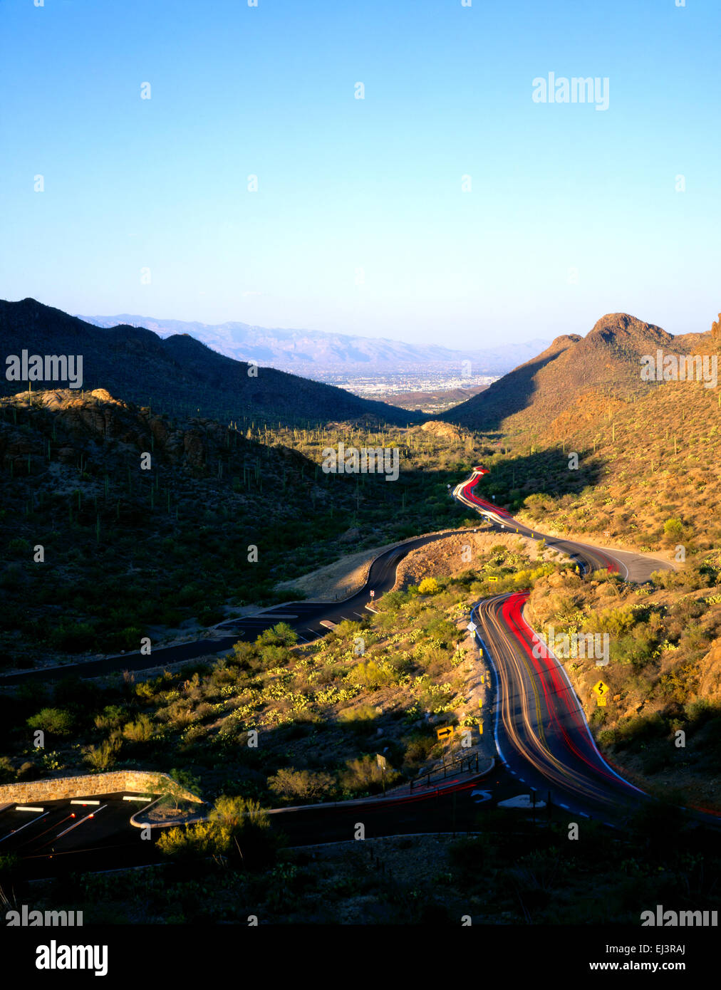 Der Weg zur Gates-Pass in den Bergen von Tucson leuchtet nach Einbruch der Dunkelheit mit der Stadt Tucson in der Ferne Stockfoto