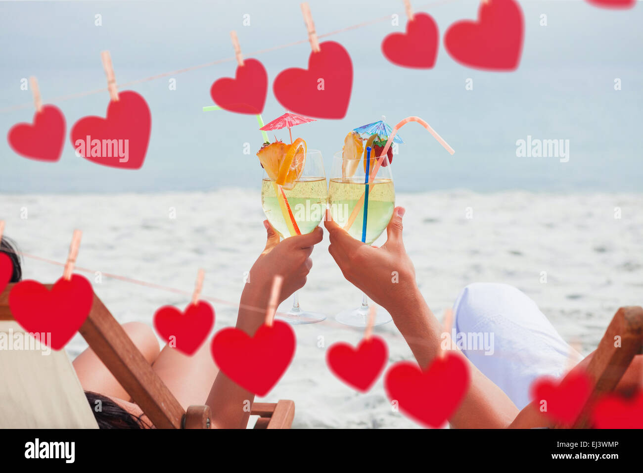 Zusammengesetztes Bild paar klirrende Gläser cocktail am Strand Stockfoto