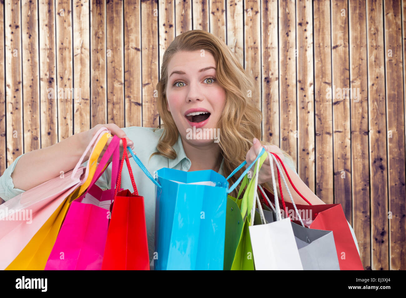 Zusammengesetztes Bild überwältigt jungen Frau mit Einkaufstüten Stockfoto
