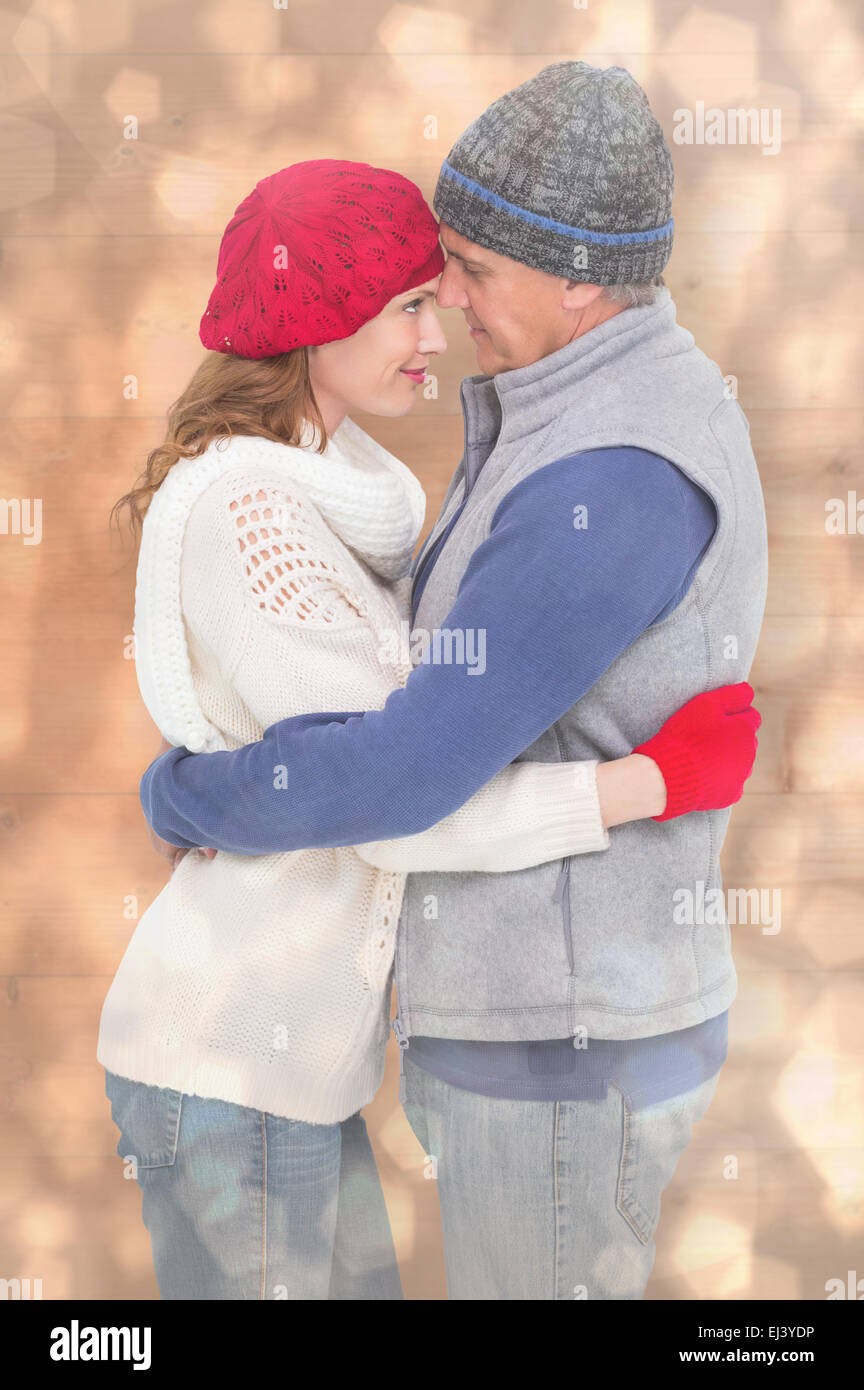 Zusammengesetztes Bild des glücklichen Paares in warme Kleidung zu umarmen Stockfoto