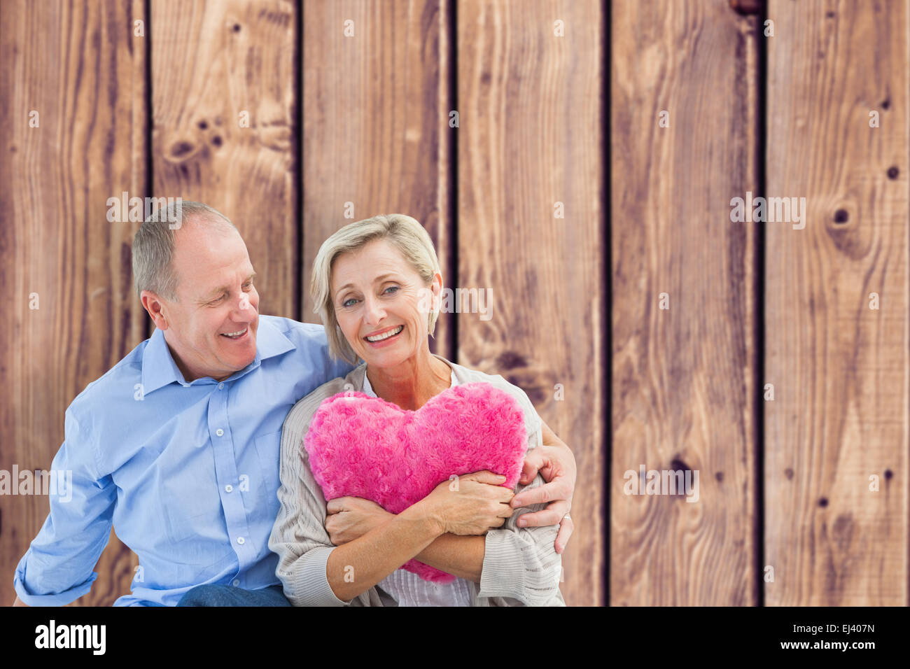 Zusammengesetztes Bild glücklich älteres Paar mit Herz Kissen Stockfoto