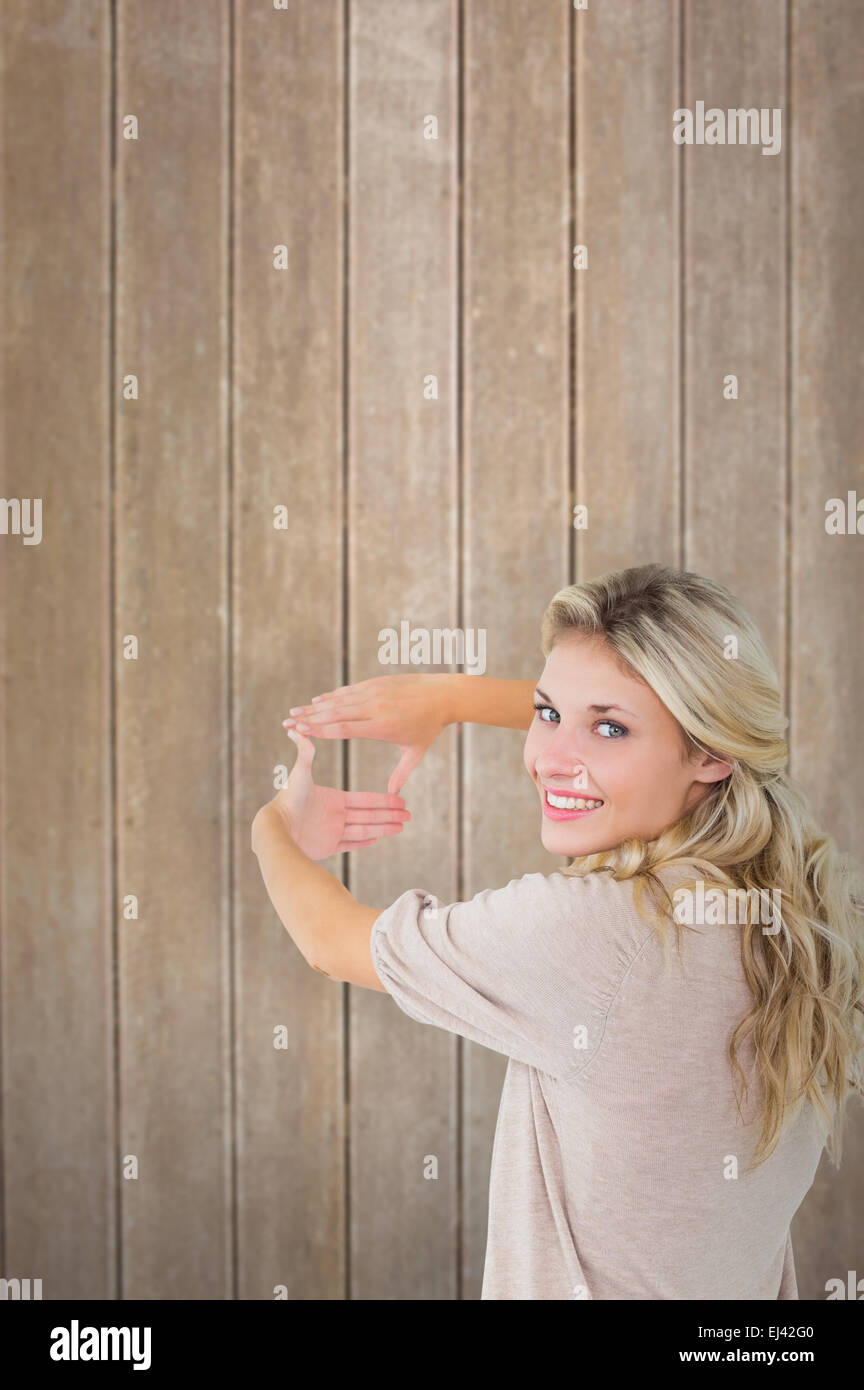 Zusammengesetztes Bild der attraktive junge blonde Rahmung mit ihren Händen Stockfoto