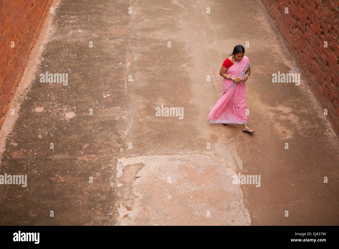 Eine Besucherin geht durch eine Gasse am alten buddhistischen Institutskomplex von Nalanda in Nalanda, Bihar, Indien. Stockfoto