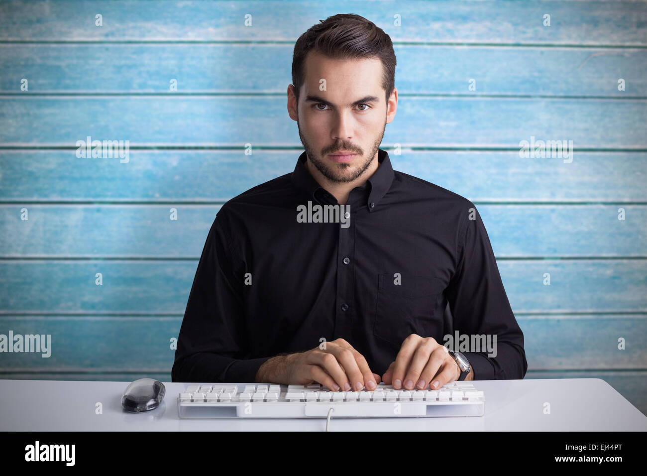 Zusammengesetztes Bild des ernsthaften Geschäftsmann über Tastatur eingeben Stockfoto