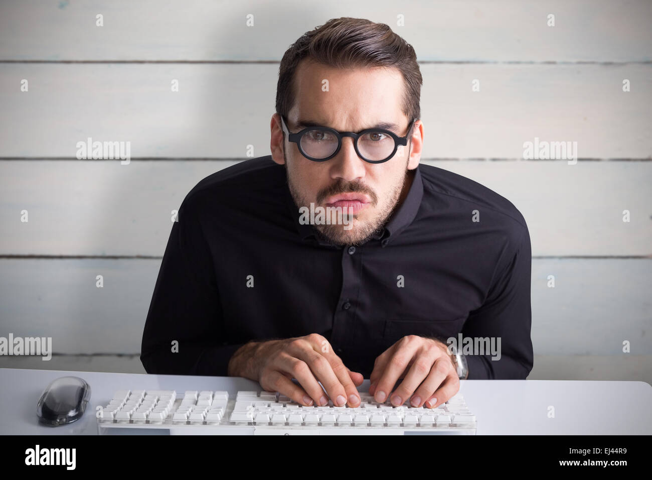 Zusammengesetztes Bild des konzentrierten Geschäftsmann mit einer Brille, die Eingabe über Tastatur Stockfoto