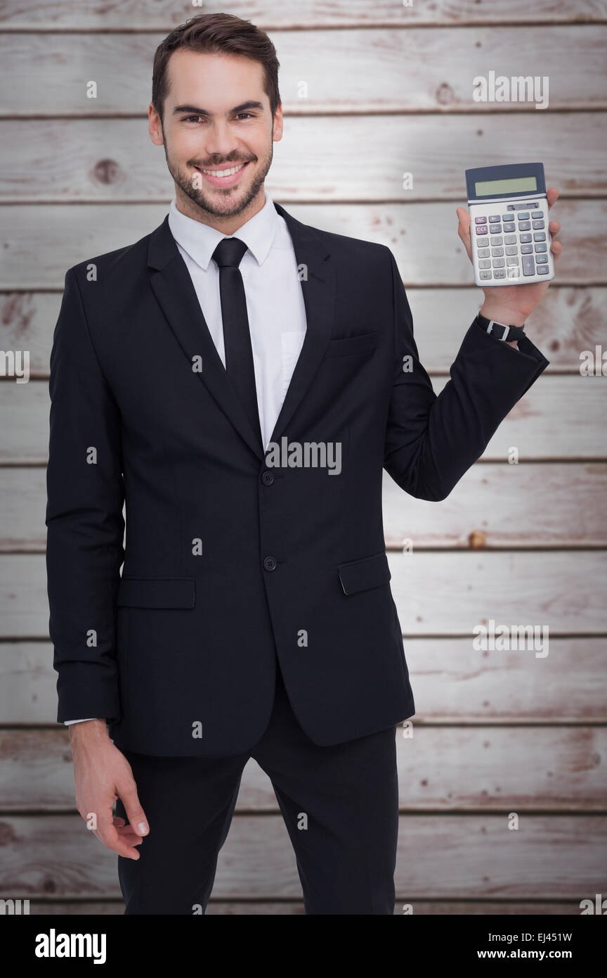 Zusammengesetztes Bild des lächelnden Geschäftsmann präsentiert einen Taschenrechner Stockfoto