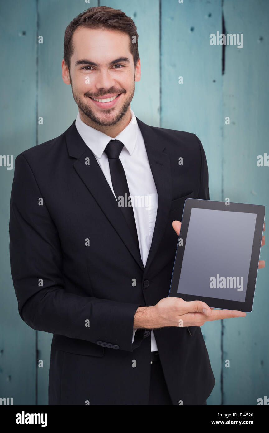 Zusammengesetztes Bild des lächelnden Geschäftsmann mit seinem TabletPC Stockfoto