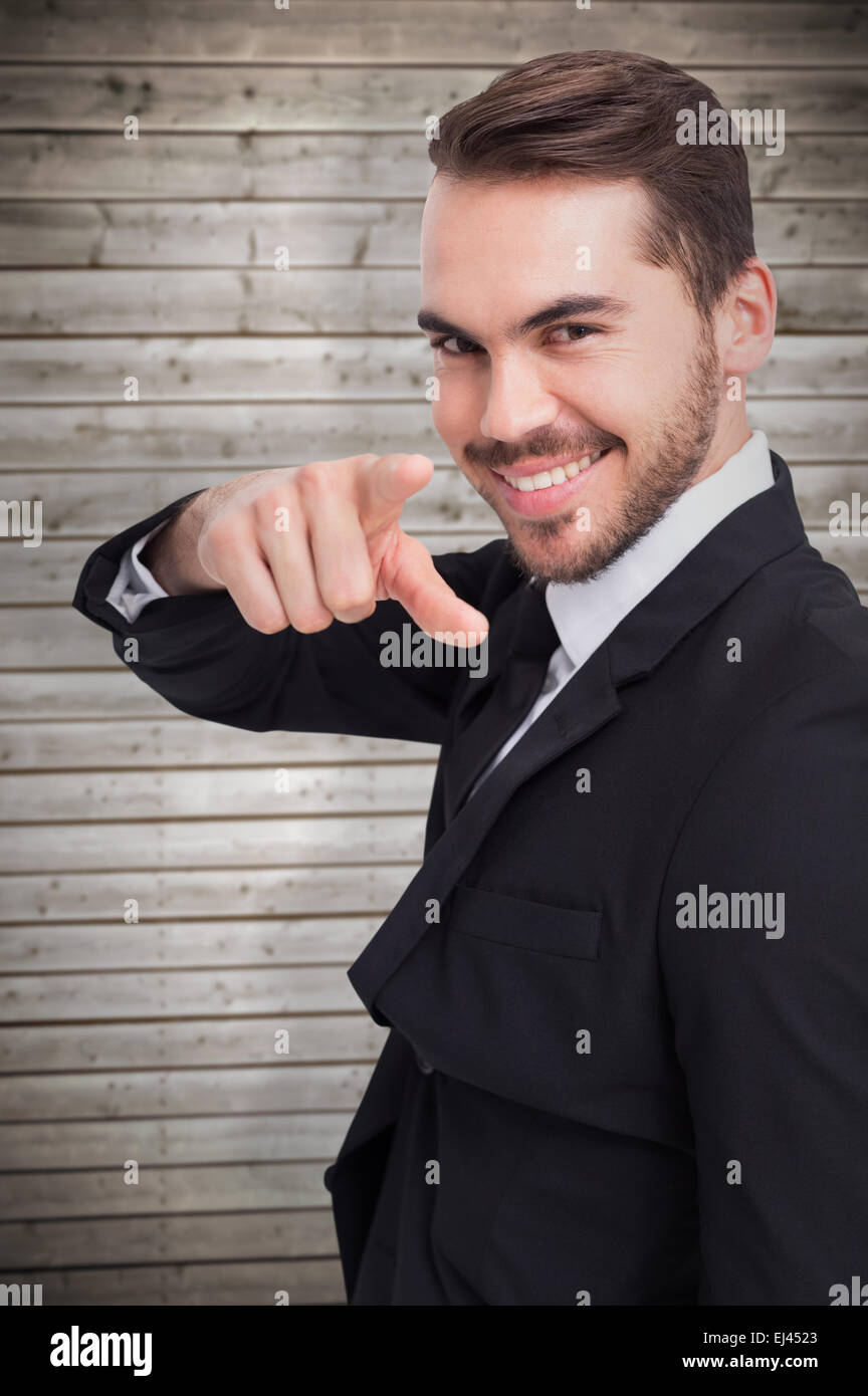Zusammengesetztes Bild des glücklichen Geschäftsmann zeigte mit dem finger Stockfoto