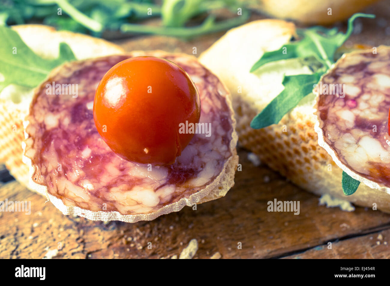 Spanische Vorspeise Tapas, Pinchos, Pincho mit Rucola, Cherry-Tomaten und Wurst Stockfoto