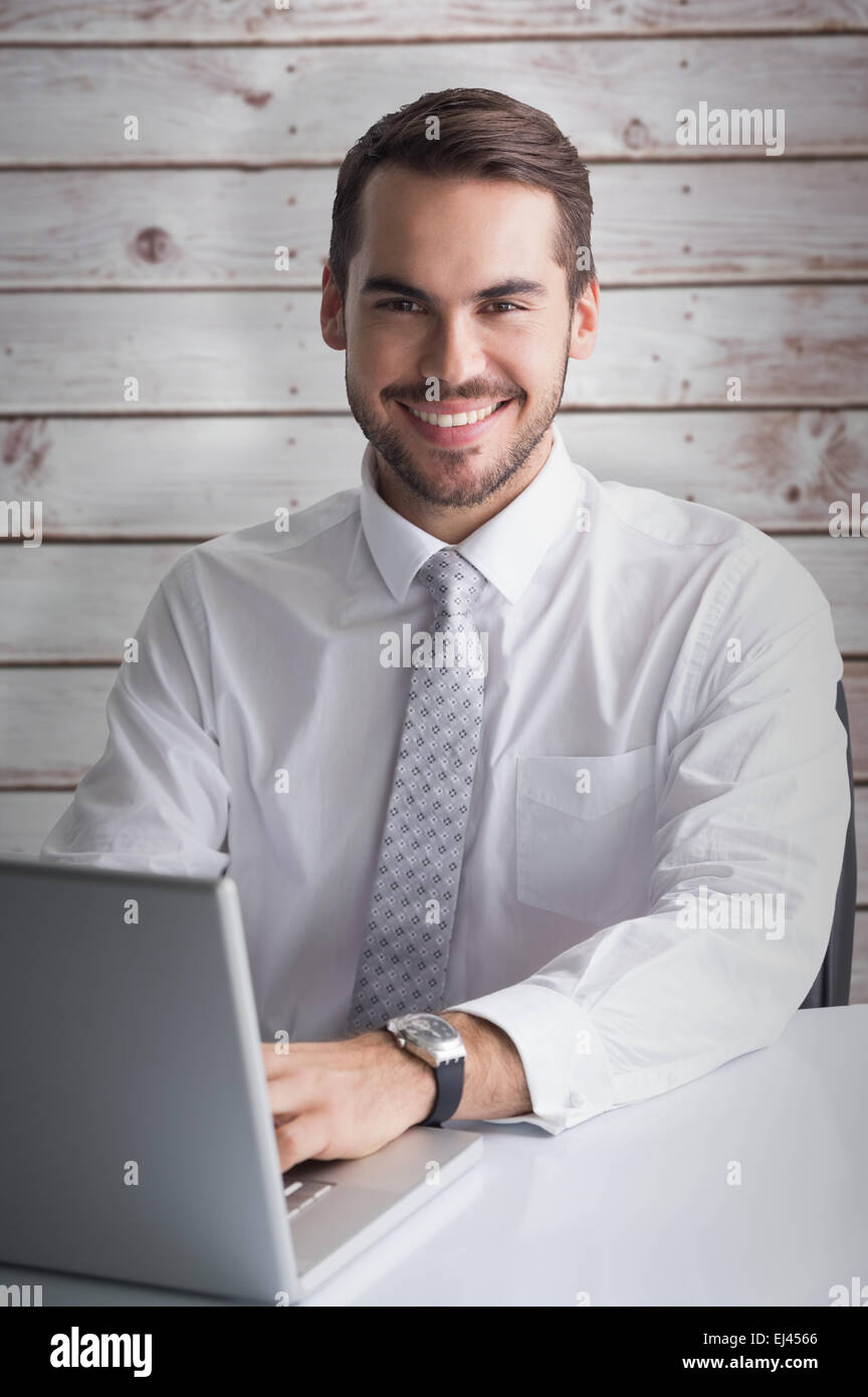 Zusammengesetztes Bild des glücklichen Geschäftsmann mit seinem laptop Stockfoto