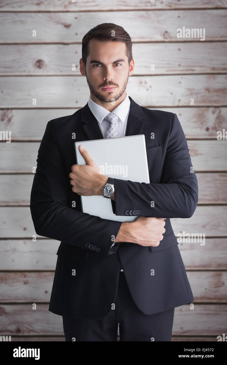 Zusammengesetztes Bild der Geschäftsmann im Anzug posiert mit seinem laptop Stockfoto