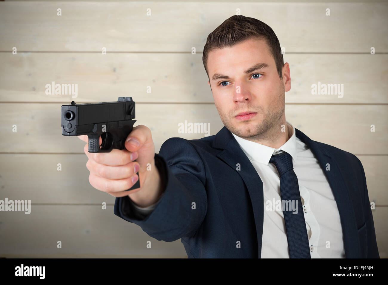 Zusammengesetztes Bild des ernsthaften Geschäftsmann mit einer Pistole Stockfoto