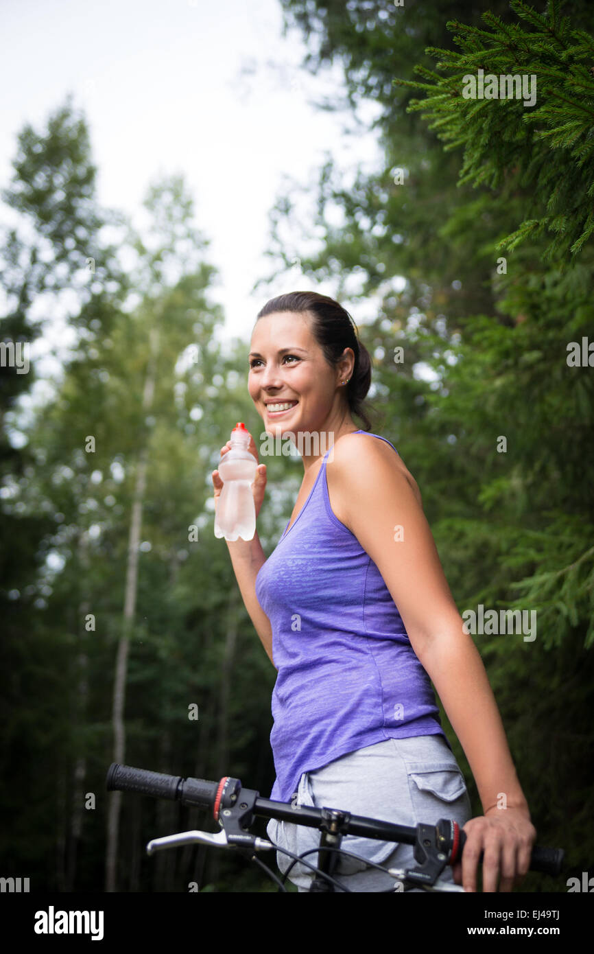 Hübsche junge Frau trinkt Wasser draußen Sommer Stockfoto