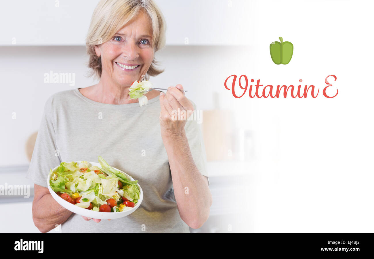 Vitamin e gegen lächelnden Frau essen Salat Stockfoto
