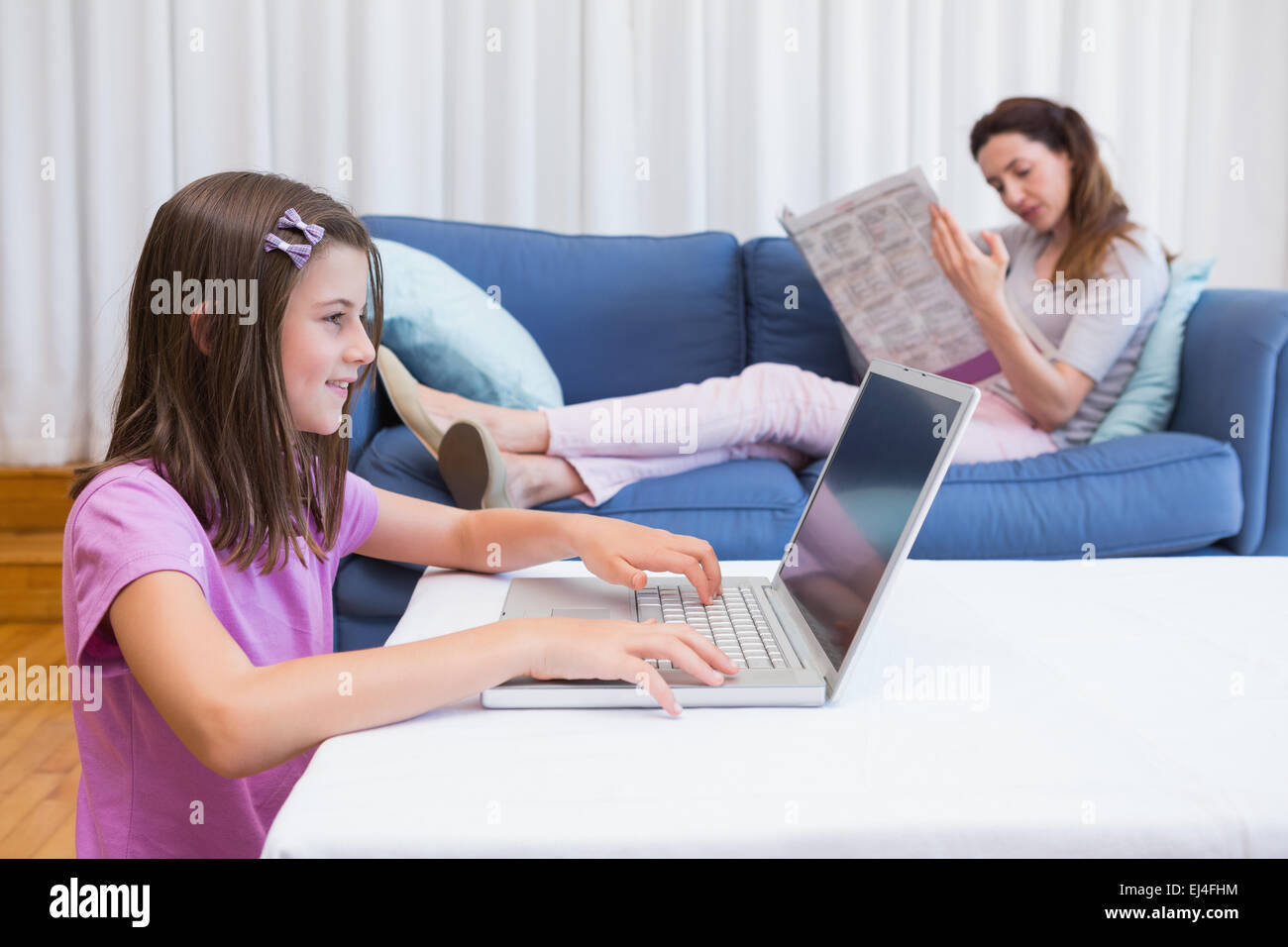 Mutter lesen Nachrichten mit Tochter mit laptop Stockfoto