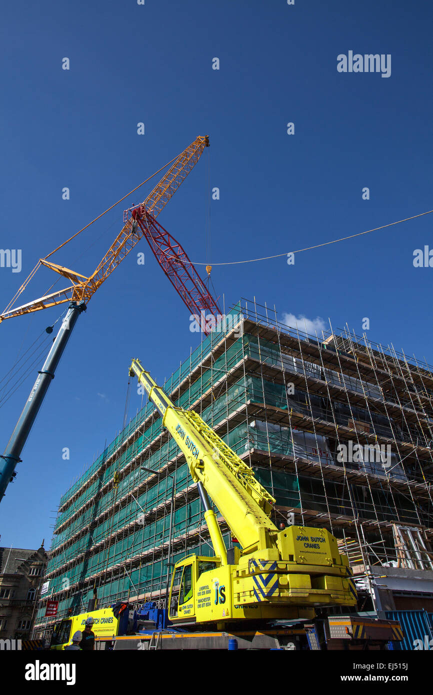 Studentenunterkunft in Liverpool, Merseyside, Großbritannien 21. März 2015. 40m hoher roter Turmdrehkran, der auf der Baustelle eines großen Komplexes von Nordic Construction verwendet wurde, der entfernt wird. Der Standort in der Hope Street ist ein Studentenzentrum mit 339 Zimmern, einem Fitnessstudio, einem Kino, Bars und Restaurants. Der Kran wird mit einem noch größeren 750 Tonnen Luffer Crane mit hydraulischen Wippauslegern demontiert (wird in engen städtischen Arbeitsräumen verwendet, wenn der Abstand zum Drehen des Jib nicht ausreicht), Einer der größten Krane dieser Art in Europa und einer von nur drei in Großbritannien. Stockfoto