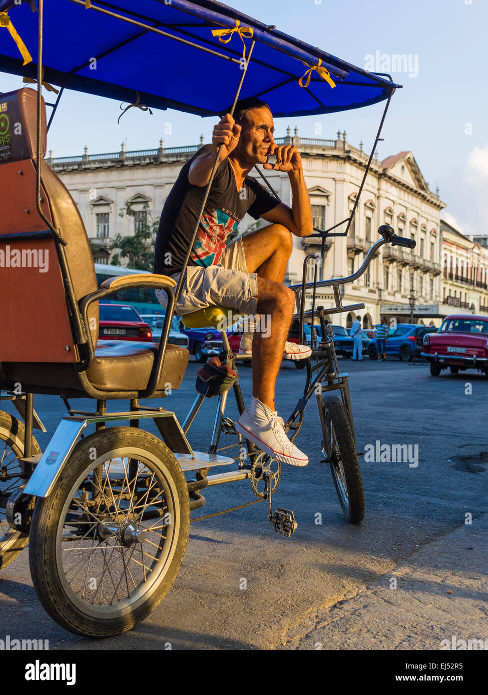 Hispanic kubanischen Rikscha Fahrer sitzt auf seiner Rikscha und wartet für Fahrer bei Sonnenuntergang. Stockfoto