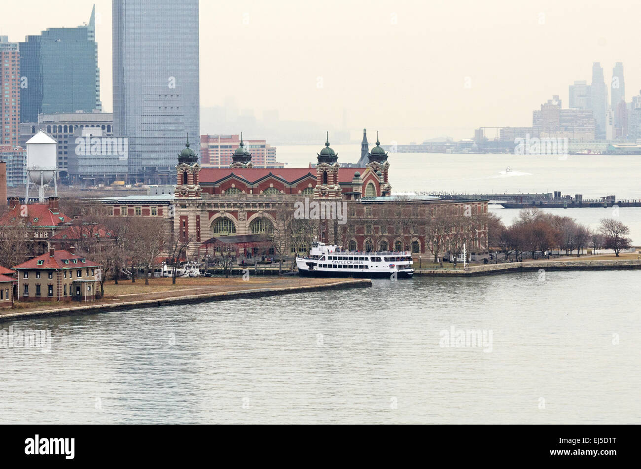 Die Gebäude der Paulus Hook von Jersey City überragen das Hauptgebäude des Ellis Island Immigration Museum. Stockfoto